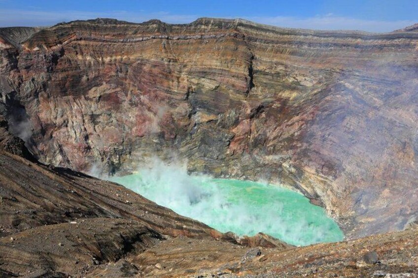 A volcanic crater with turquoise water and steam. 3