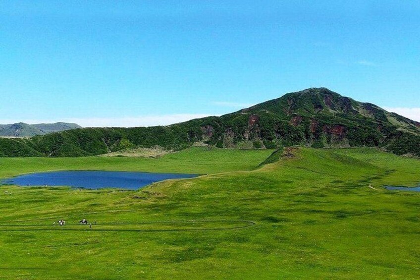 A mountain, a lake, and a grassy field. 5