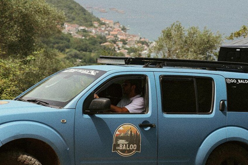 Off-road Jeep driving above the Bay of Kotor, showcasing scenic coastal views along the Montenegro tour route. 4
