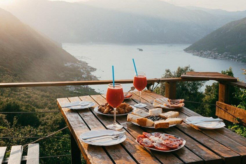 Sunset snack and drinks overlooking the Bay of Kotor, featuring local Montenegrin delicacies served on a scenic terrace. 5