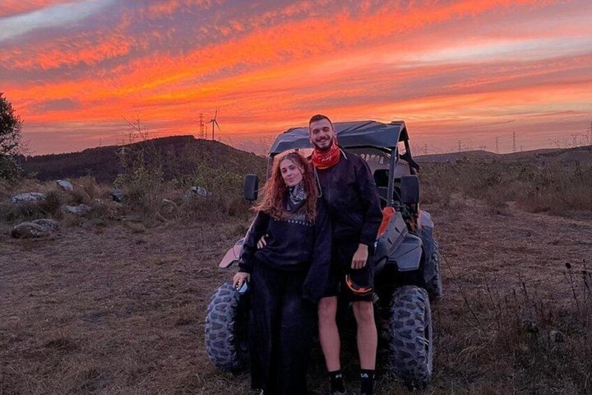 A sunset with a vehicle and two people. 2