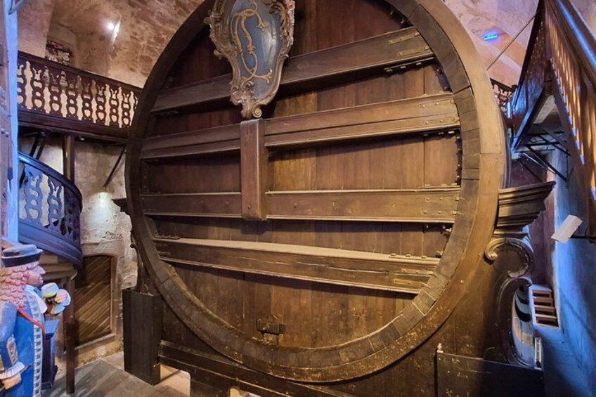 Een grote houten deur met gedetailleerde houtsnijwerken en een metalen handgreep. 5