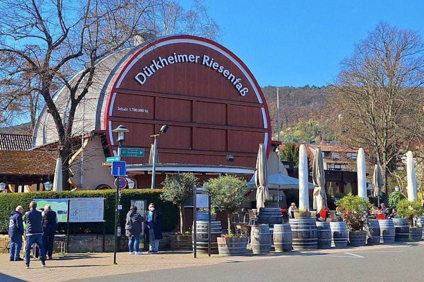 A large building with the sign 'Dürkheimer Riesenspaß' and a mountain in the background. 1
