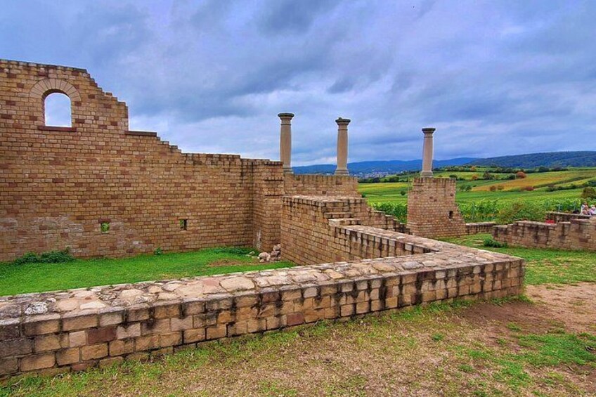An ancient brick structure with columns and a surrounding wall. 5