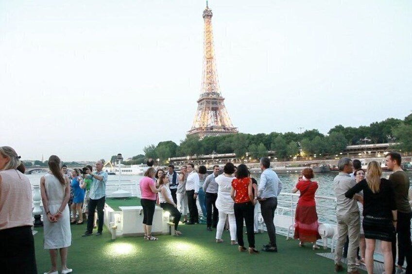 A group of people on a boat near the Eiffel Tower. 5