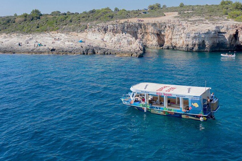 A boat named 'Rio boat' on a body of water with a rocky coastline in the background. 3