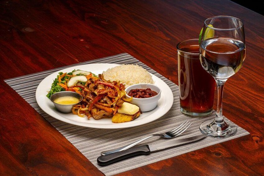A plate of food with rice, vegetables, and a drink on a table. 2