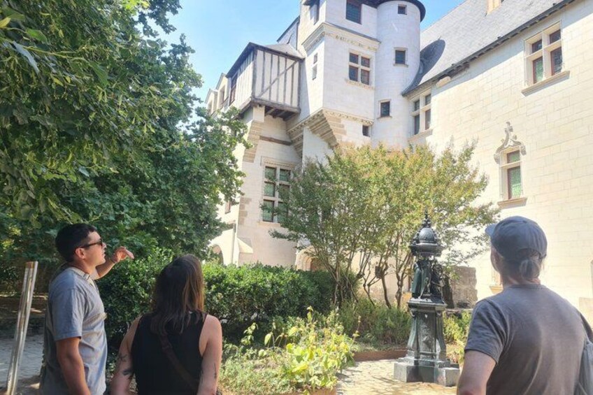 A group of people standing in a courtyard with a large building in the background. 4