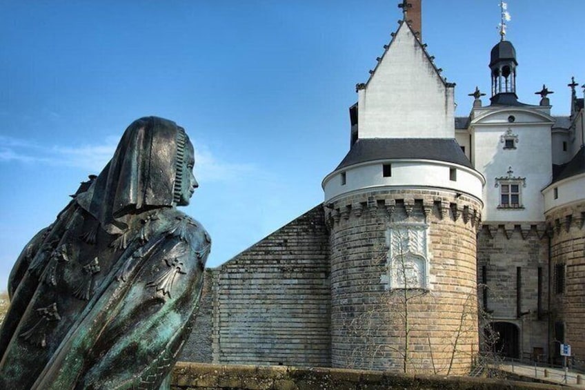 A statue of a woman and a castle with a round tower. 1