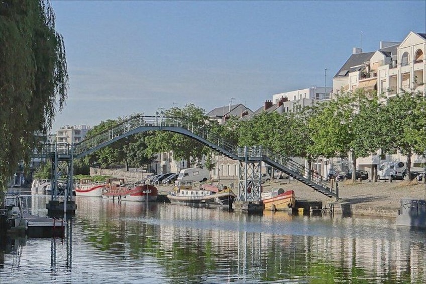 A river with boats, a bridge, and buildings along the shore. 4