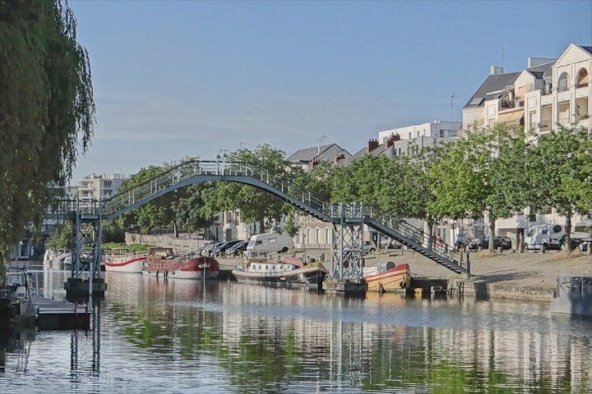 A river with boats, a bridge, and buildings along the banks. 4
