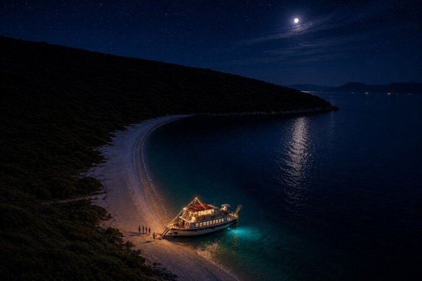 A boat docked at a beach at night with a lit-up building nearby. 1