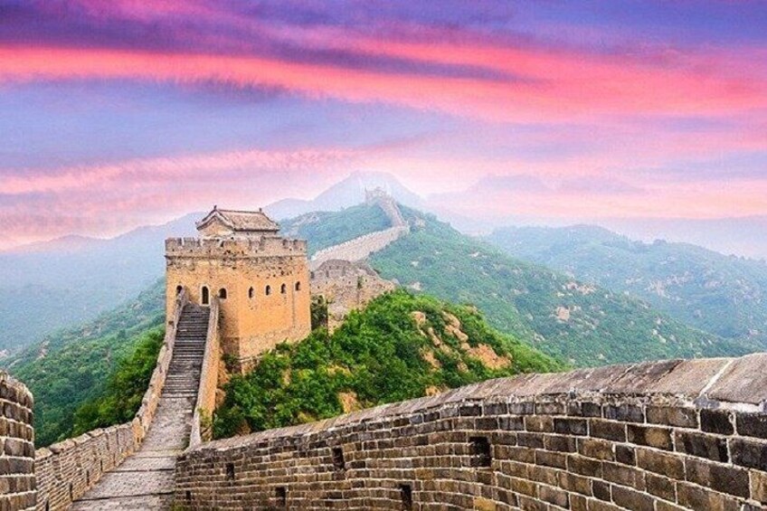 The Great Wall of China with a tower and watchtowers, surrounded by lush green hills and mountains. 3
