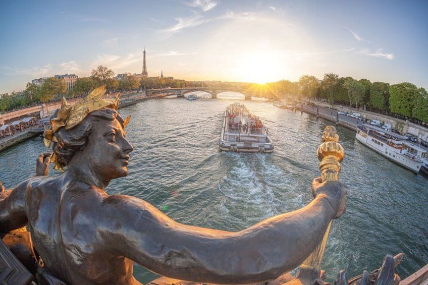 A statue overlooking a river with boats and a tower in the background. 5