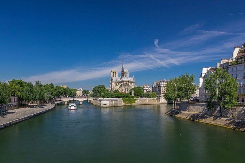A river with a bridge, a boat, and a cathedral in the background. 1