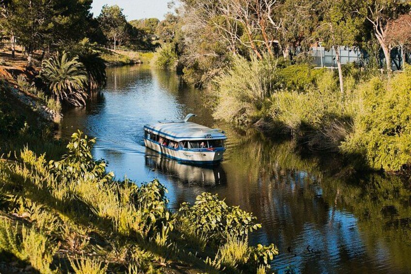 A river with a boat, surrounded by greenery and trees. 1