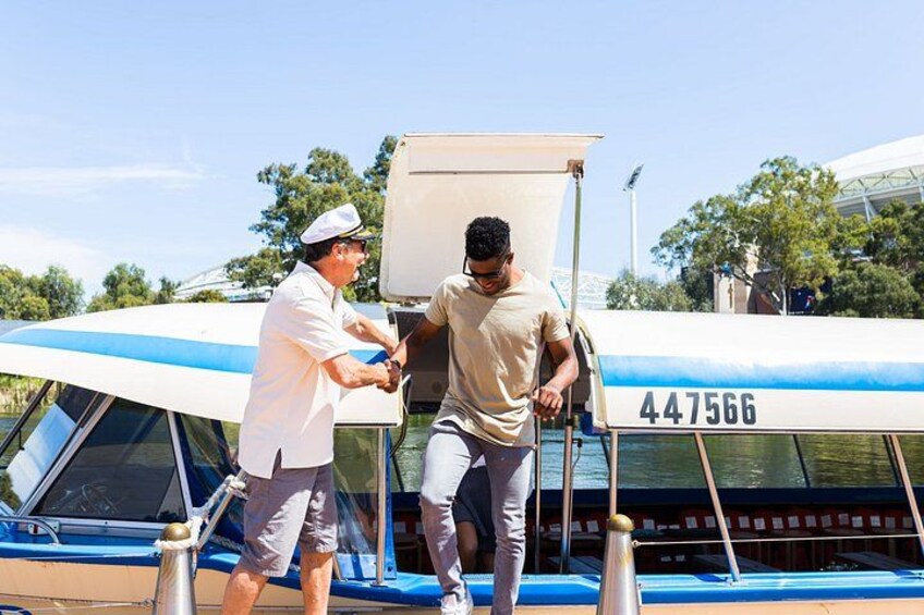 Two people on a boat with a blue and white color scheme, a number '447566' on the side, and a clear sky in the background. 2