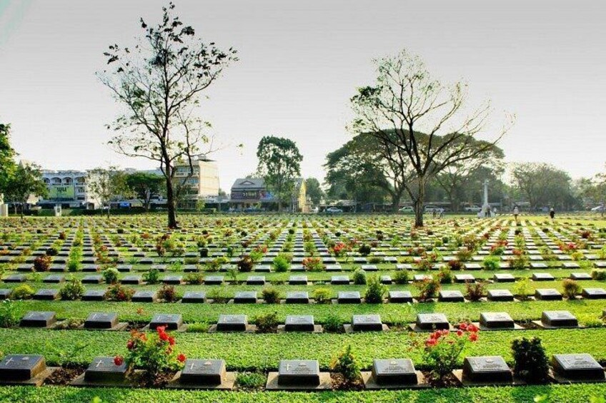 A cemetery with rows of graves, trees, and a clear sky. 5