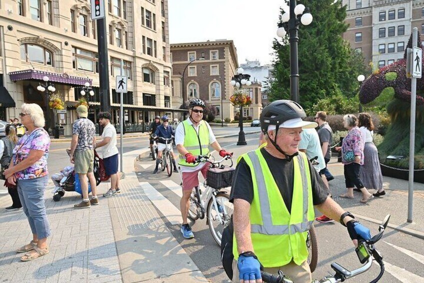 A street scene with cyclists in reflective vests, pedestrians, and historic buildings. 5