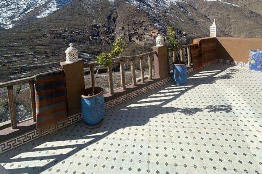 A terrace with potted plants and a view of a mountainous landscape. 3