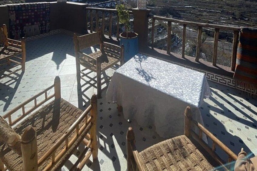 A rooftop terrace with a table, chairs, and a patterned tablecloth. 5