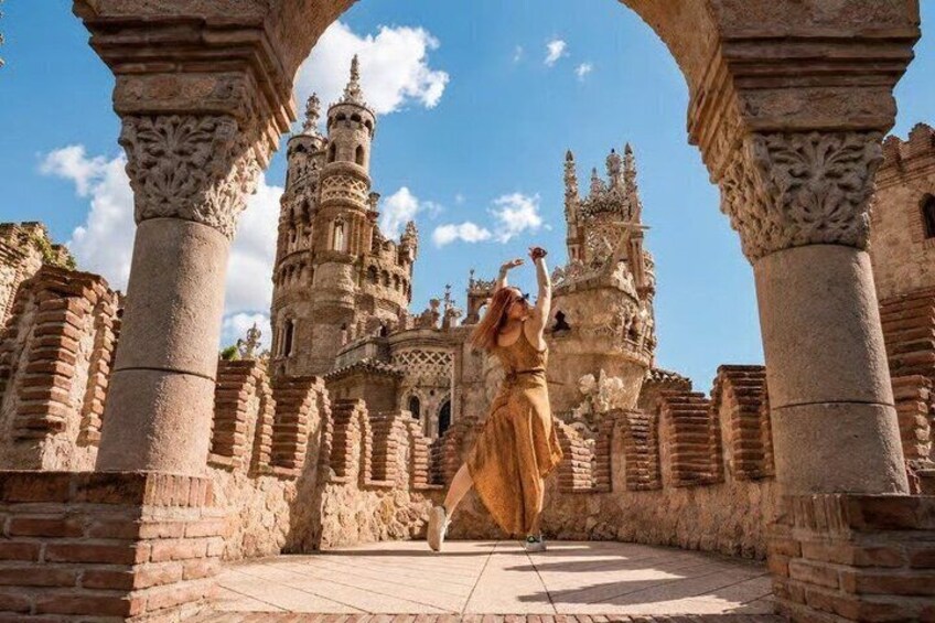 A person in a dress dancing in front of a historic building with intricate architecture. 2