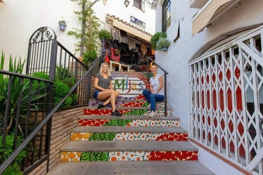 A staircase with colorful tiles, a metal gate, and a building with a sign. 5