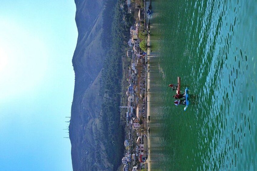 A kayaker on a river with a cityscape in the background. 5