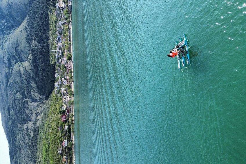 A boat on a calm lake with a mountainous landscape in the background. 3
