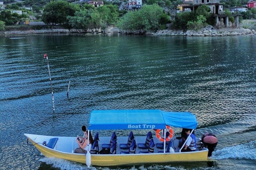 A yellow boat with a blue canopy labeled 'Boat Trip' on a river. 2