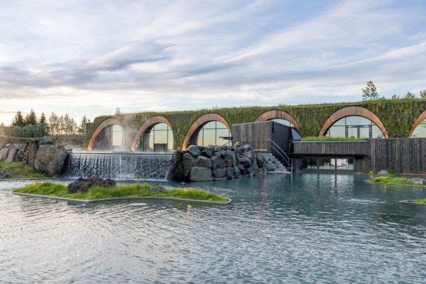 A modern building with arched windows and a water feature. 2