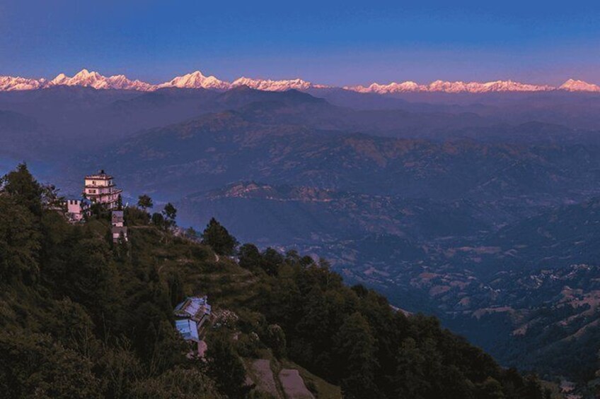 A mountainous landscape with a traditional multi-tiered building and snow-capped peaks in the distance. 4