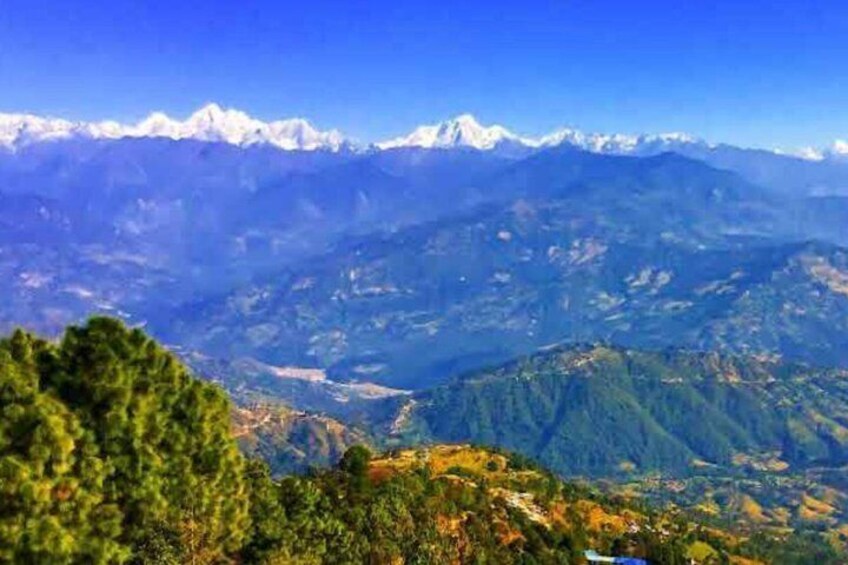 A mountainous landscape with snow-capped peaks, dense forests, and a valley below. 1