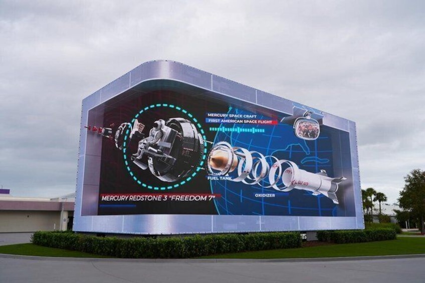 A large outdoor advertisement for the Mercury Spacecraft, featuring the Mercury Redstone 3 'Freedom 7' and the Space Shuttle. 4