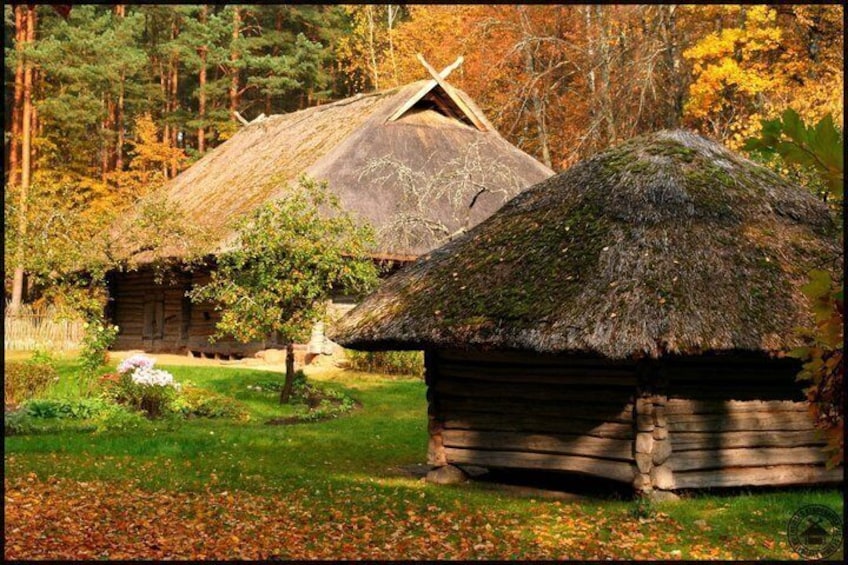 A traditional wooden house with a thatched roof surrounded by autumn foliage. 3