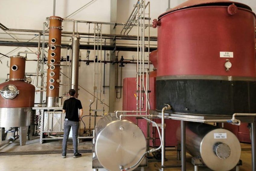 A distillery with large red tanks and stainless steel equipment. 5