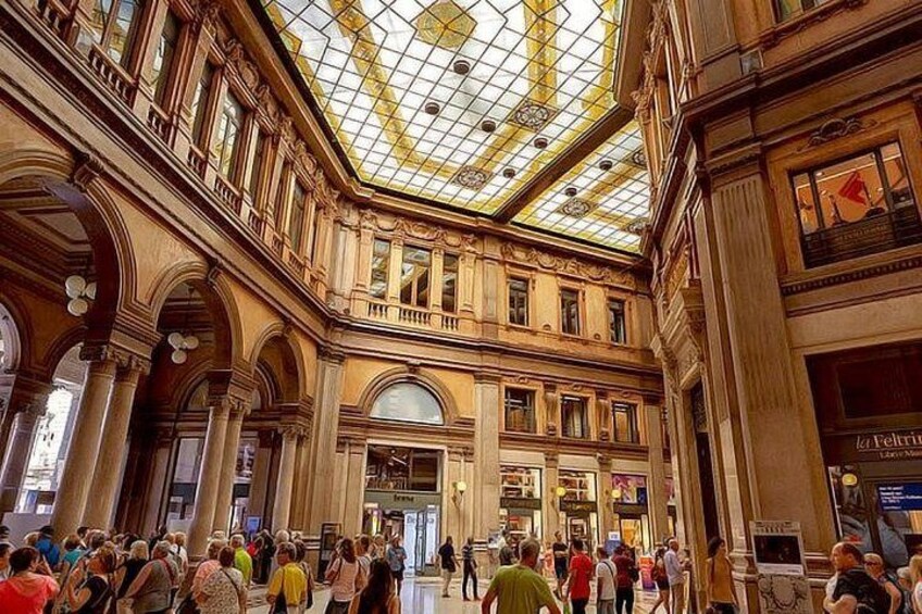 A crowded indoor space with a high ceiling and ornate architecture. 2