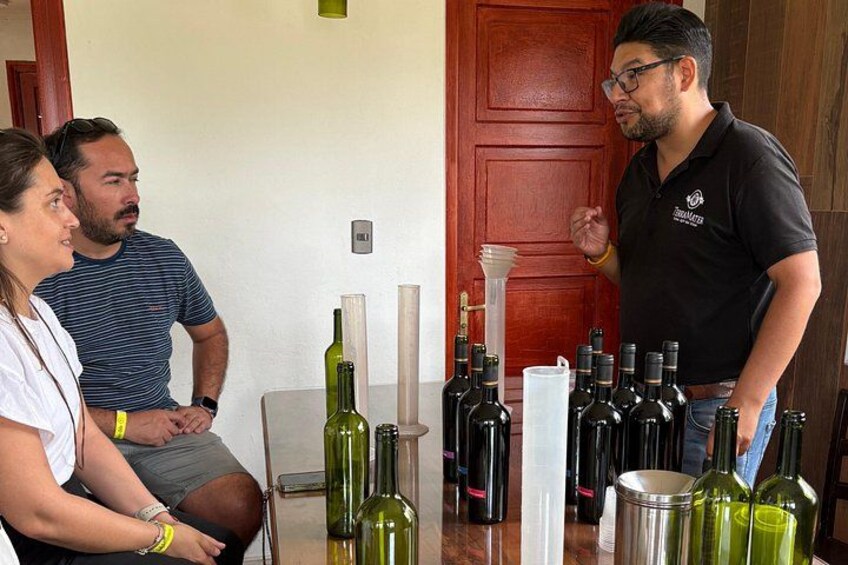 A group of people around a table with wine bottles and a wine decanter. 5
