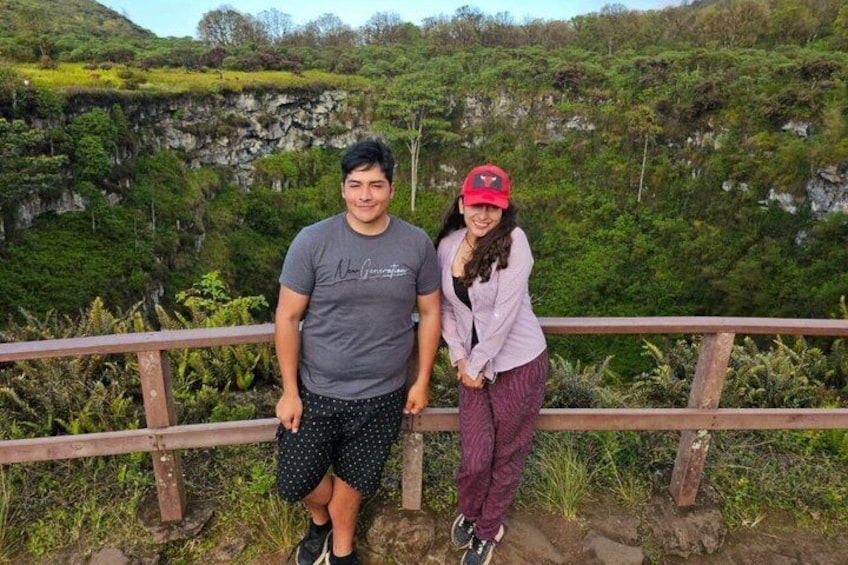 Two people standing on a wooden railing with a mountainous landscape in the background. 4