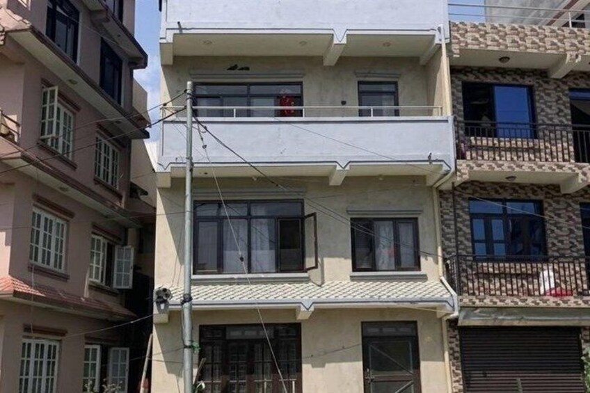 A multi-story residential building with balconies and a visible power line. 2