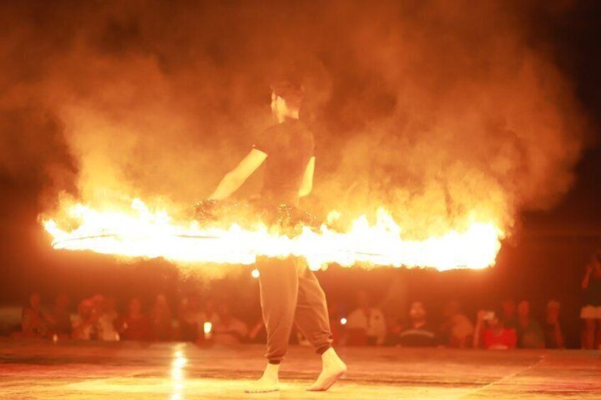 A person performing with a fire act, surrounded by an audience. 2