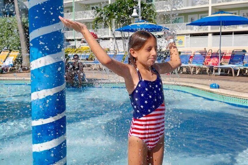 A child playing in a pool with water splashing around. 3