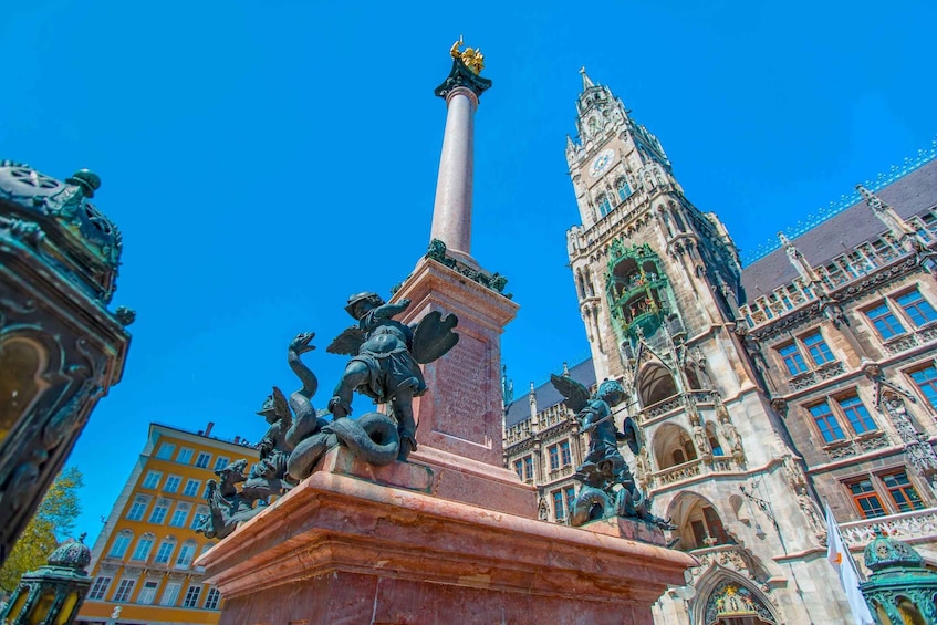 A historical monument with a tall column and statues, surrounded by ornate buildings. 3