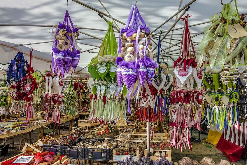 A market stall with various handmade crafts and decorations, including purple and green items hanging from the ceiling. 4