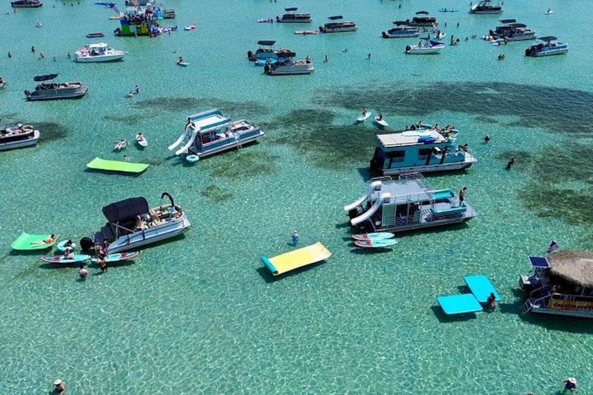 A clear turquoise sea with numerous boats and people. 3
