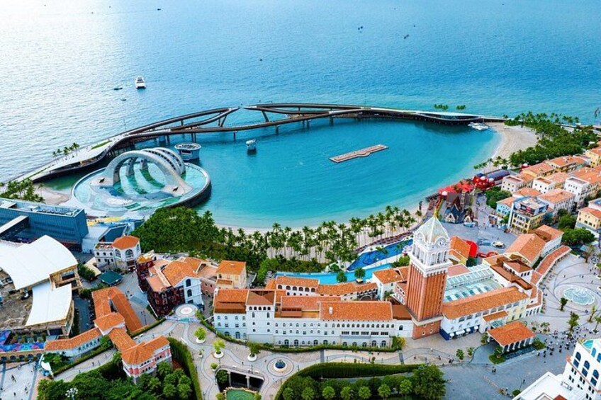 A coastal town with a prominent church, a marina, and a bridge connecting to an island. 1