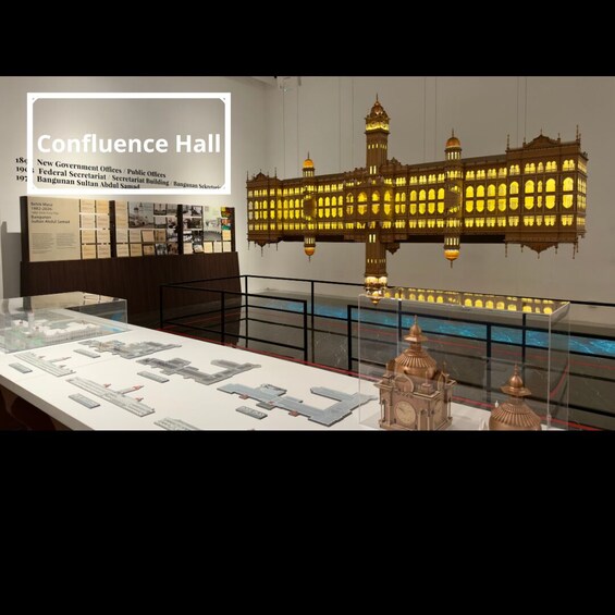 A museum exhibit with a model of a grand building, architectural plans, and informational panels. 3