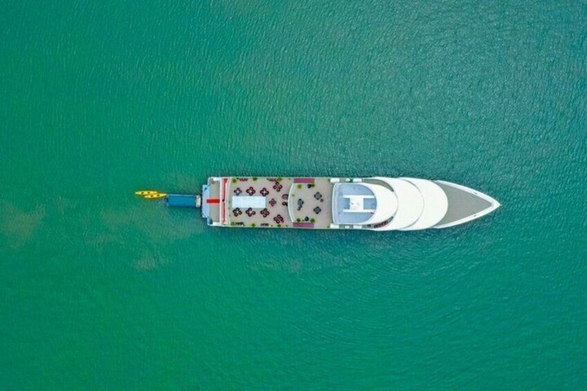 A white boat with a cabin and deck chairs on turquoise water. 4