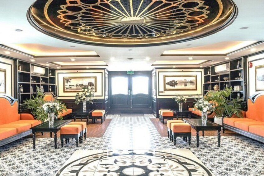 A luxurious lobby with ornate ceiling design, plush seating, and decorative vases. 5