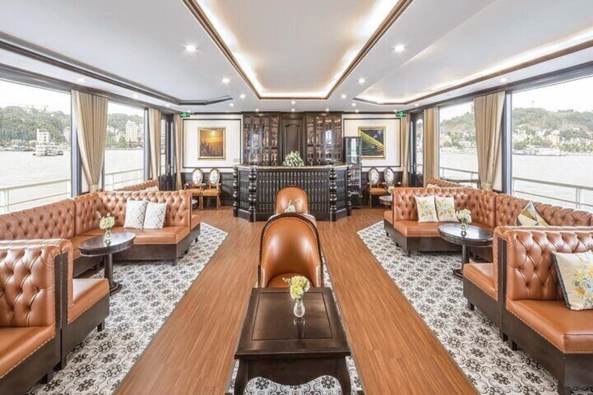 A luxurious interior with leather sofas, a central coffee table, and a bar area. 3